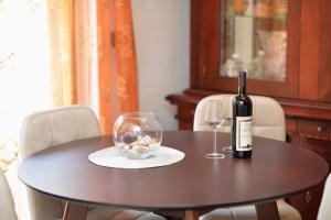 eine Flasche Wein und ein Glas auf dem Tisch in der Unterkunft Apartment Nikolija in Dobrota