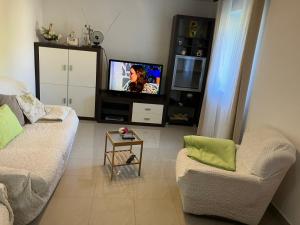 a living room with two chairs and a flat screen tv at Apartman CELIJA in Barban