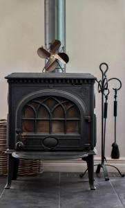 a black stove with a fan on top of it at The Cosy Cottage in Zeewolde