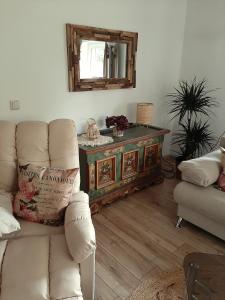 a living room with a couch and a table with a mirror at Haus Waldblick in Liebenwalde