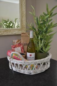 a basket with a bottle of wine and a plant at The Cosy Cottage in Zeewolde