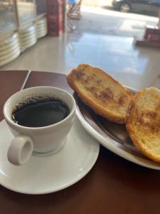 una taza de café y dos tostadas en un plato en Pousada viracopos, en Campinas