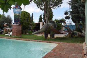 a statue of an elephant on a slide next to a pool at Castillo Esmeralda in Las Gabias