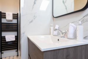 a bathroom with a sink and a mirror at RÌGH Properties - Luxurious City Centre Three Bedroom Apartment in Edinburgh