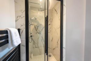 a shower with a glass door in a bathroom at RÌGH Properties - Luxurious City Centre Three Bedroom Apartment in Edinburgh