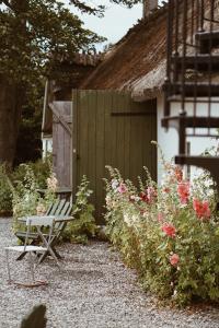 a garden with a bench and a fence and flowers at Axatorpsgården in Trelleborg