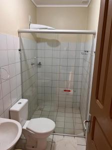 a bathroom with a shower with a toilet and a sink at Hotel Peritoró in Peritoró +6 photos