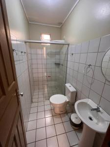 a bathroom with a toilet and a sink at Hotel Peritoró in Peritoró