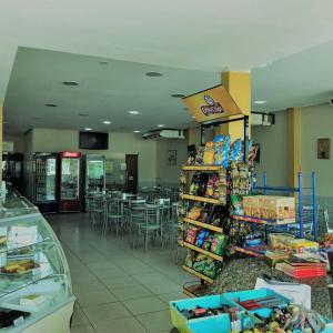 a grocery store aisle with a table and chairs at Hotel Peritoró in Peritoró