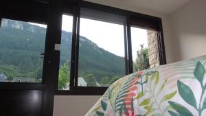a bedroom with a bed with a view of a mountain at Studio Gîtes Au Pont de la Ginéze in Barjac