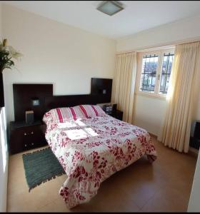 1 dormitorio con 1 cama con manta roja y blanca en Departamento de categoría en corazón de Miramar en Miramar