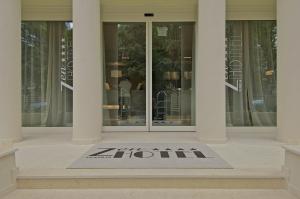 a sign in front of a building with a door at Zen Hotel Versilia in Marina di Pietrasanta