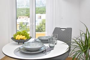 una mesa blanca con un bol de fruta en ella en Luxury Apartments Luna, en Tučepi