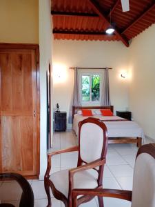 a bedroom with two beds and a chair and a window at Hotel Anachoreo in Santa Fé