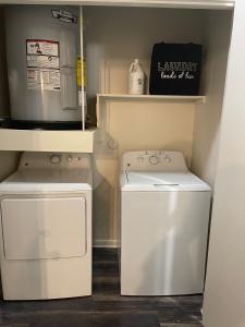 uma lavandaria com uma máquina de lavar roupa e uma máquina de lavar roupa em 2 bedroom 4 beds Apartment on the heart of Legacy West em Plano