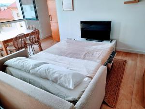 ein Wohnzimmer mit einem Sofa und einem Flachbild-TV in der Unterkunft Apartamento en Sada con piscina in Sada