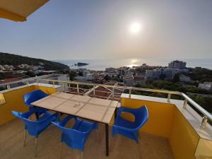 una mesa y sillas en un balcón con vistas al océano en Apartments MileS, en Utjeha