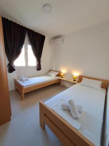 1 dormitorio con 2 camas y ventana en Apartments MileS, en Utjeha