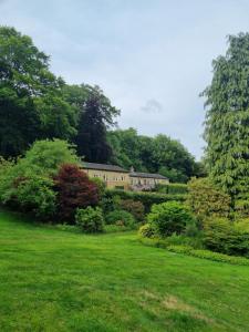 a house in the middle of a green field at Lakeside cottage in Huddersfield