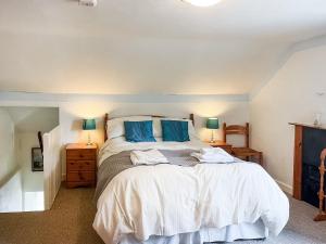 a bedroom with a large bed with blue pillows at Beech Cottage - Uk44731 in Hartington