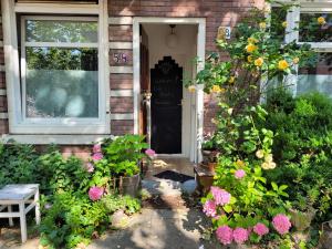 a front door of a brick house with flowers at H 58 in Amsterdam