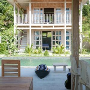 a house with a pool and a table and chairs at Silir Villa "your cozy home" in Mataram