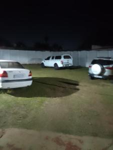 three cars parked in a parking lot at night at MEDUPI 2 Guesthouse. in Kempton Park
