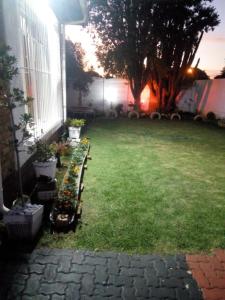 a yard with a bench in front of a house at MEDUPI 2 Guesthouse. in Kempton Park