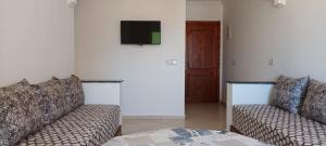 a living room with two couches and a tv at nour in Oued Laou