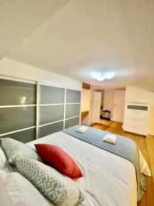 1 dormitorio con 1 cama blanca grande con almohadas rojas en Apartamento "Villa Marinera", en Luanco