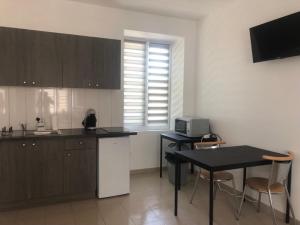 a kitchen with a table and a counter top at Appart'Evry 1G in Évry-les-Châteaux +2 photos