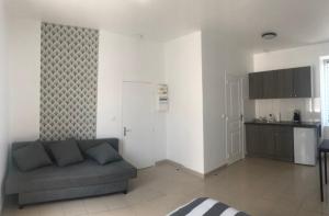 a living room with a couch and a kitchen at Appart'Evry 1G in Évry-les-Châteaux