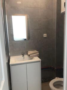 a bathroom with a white sink and a toilet at Appart'Evry 1G in Évry-les-Châteaux