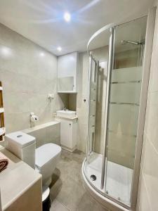 a white bathroom with a shower and a toilet at Apartamento "Villa Marinera" in Luanco