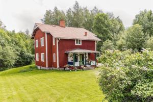 a red barn in the middle of a yard at Appartement in de natuur! in Fredriksberg