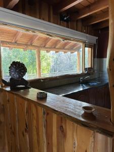 a kitchen with a counter top and a window at Cabañas El Aljibe - Meliquina in Villa Meliquina