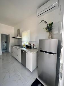 a kitchen with white cabinets and a refrigerator at Appartement BM in Drage