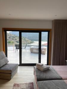 um quarto com uma cama e uma porta de vidro deslizante em Douro Visit House em Torre de Moncorvo