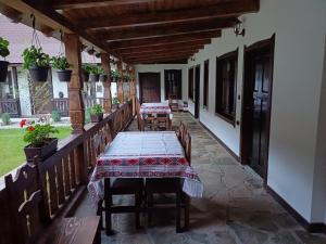 a patio with a long table and chairs on it at Casuta din Valea Regilor in Grădiştea de Munte