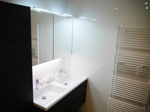 a white bathroom with a sink and a mirror at Residentie Sweetnest met 3 dubbel kamers in Knokke-Heist