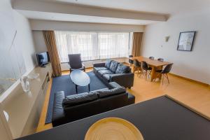 een woonkamer met een bank en een tafel bij Residentie Sweetnest met hotelservice à la carte in Knokke-Heist