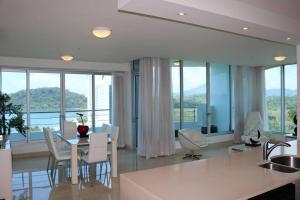 uma cozinha e sala de jantar com mesa e cadeiras em 08A Stunning Rooftop Pool-360 Views of Sea & Canal em ArraijÃ¡n