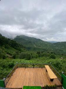 a wooden deck with a bench on top of a mountain at Gohali Bungalov in Trabzon