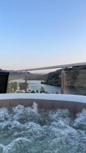 a tub filled with water with a bridge in the background at Douro Visit House in Torre de Moncorvo