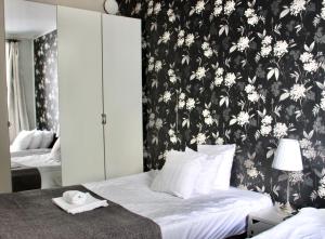 ヘルシンキにあるオルキデア カンピの白黒の花の壁紙を用いたベッドルーム1室