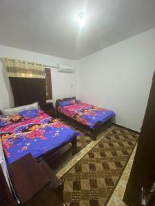 a room with two beds in a room with a checker floor at شالية مفروش قرية سما العريش in El Arish