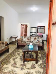 uma sala de estar com um sofá e uma mesa de centro em شالية مفروش قرية سما العريش em El Arish