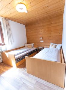 2 Betten in einem Zimmer mit Holzdecken in der Unterkunft Haus Theresia Rüf in Au im Bregenzerwald