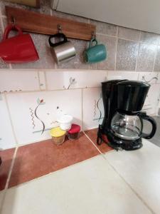 a coffee maker on a counter in a kitchen at Nirvana Apartament Hostal in Alajuela City