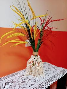 un vase avec des fleurs assis sur une table dans l'établissement Nirvana Apartament Hostal, à Alajuela